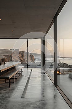 A modern house with a large glass window looking out onto the ocean
