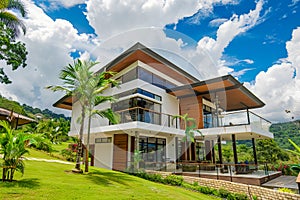 A modern house with lush green grass and trees