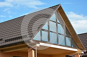 Modern house with metal roofing, panoramic window, skylight, roof window and rain gutter system. photo