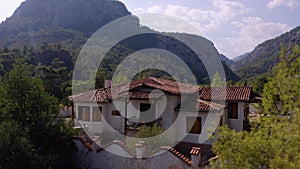 Modern house in the mountains forest. Cloudy sky in the background.