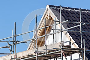 Modern house roof construction with scaffold pole platform