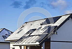 Modern house roof with solar panels covered with snow