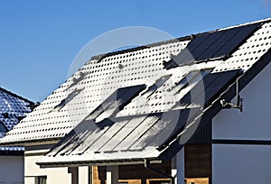 Modern house roof with solar panels covered with snow