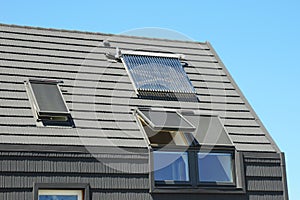 Modern House Roof with Solar Water Heater, Solar Panels and Skylights. Solar water panel heating. photo