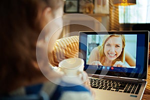 Modern housewife having video chat on computer