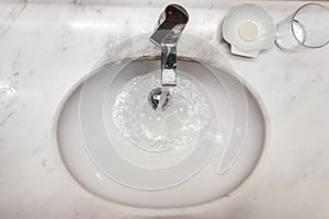 Modern hygienic wash basin with running water from tap faucet