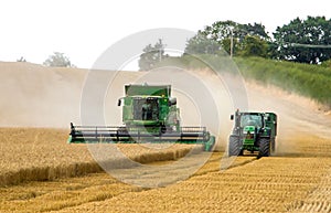 Modern 9780i cts john deere combine harvester cutting crops corn wheat barley working golden field