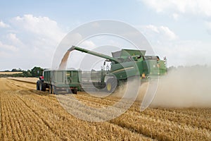 Modern 9780i cts john deere combine harvester cutting crops corn wheat barley working golden field