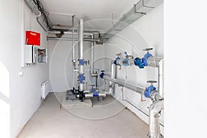 Modern independent heating system in boiler room. Pipelines, water pump, valves, manometers
