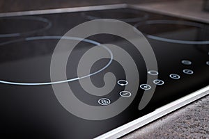 Modern induction electric hob cooker with control panel buttons. Electric hob detail closeup. Stove top panel controls