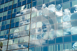 Modern industrial building with glass. Reflection of blue sky wi