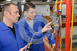 Modern industrial machine operator working with apprentice