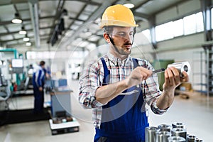 Modern industrial machine operator working in factory