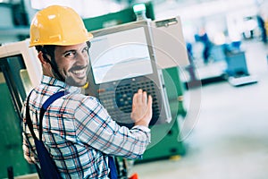 Modern industrial machine operator working in factory