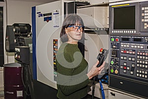 Cute woman cnc machine operator at work.