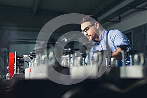 Modern industrial machine operator working in factory. Worker on the machine