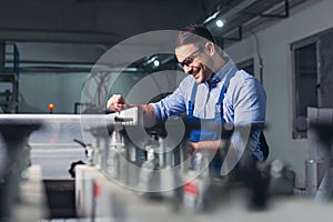 Modern industrial machine operator working in factory. Worker on the machine