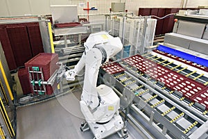 Modern industrial robot in food company - industrial production of bakery products on an assembly line