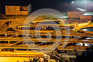 Modern industrial wastewater treatment plant at night. Aerial view of sewage purification tanks