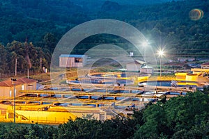 Modern industrial wastewater treatment plant at night. Aerial view of sewage purification tanks