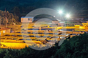 Modern industrial wastewater treatment plant at night. Aerial view of sewage purification tanks