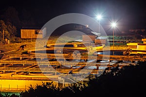 Modern industrial wastewater treatment plant at night. Aerial view of sewage purification tanks