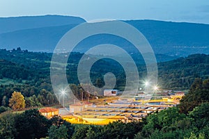 Modern industrial wastewater treatment plant at night in Mountainous region. Aerial view