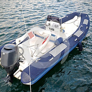 Modern inflatable boat with engine in the sea near shore