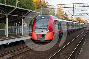 Modern intercity high speed train at sunset. Commercial suburban railroad transportation concept.