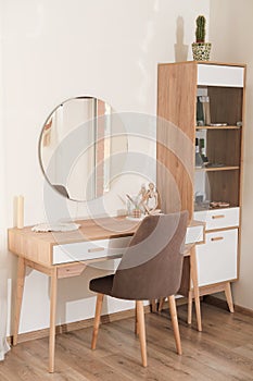 modern interior of bedroom, dressing table with mirror and soft upholstered chair. trendy minimal style decor. vertical