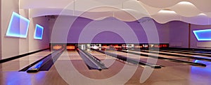 Modern interior of bowling hall, panoramic view of wooden bowling lanes.