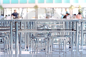 Modern interior of cafeteria or canteen with stainless steel chairs and tables