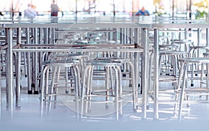 Modern interior of cafeteria or canteen with stainless steel chairs and tables