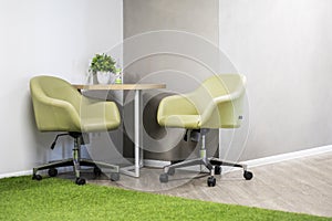 modern interior with concrete walls with two office chairs and a round wooden table