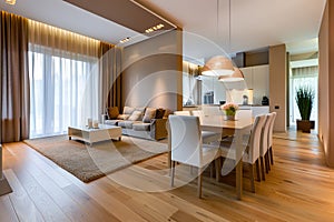 Modern interior design of apartment, dining room with table and chairs, empty living room with beige wall, panorama