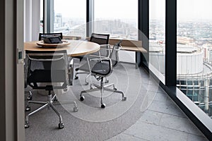 Modern interior design for an office with a round table and chairs near panoramic windows