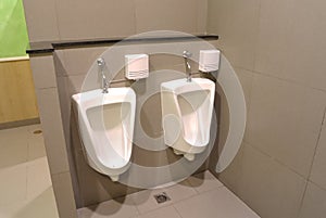 Modern interior design of white ceramic urinals for men in new t