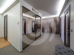 Modern interior of entrance hall in house. Mirror sliding door wardrobe.