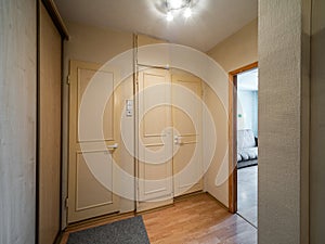 Modern interior of hall in apartment. Closed white doors.