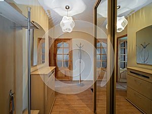 Modern interior of hall in apartment. Wardrobe with sliding door. Wooden door.