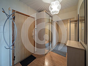 Modern interior of hall in apartment. Wardrobe with sliding door. Wooden door.