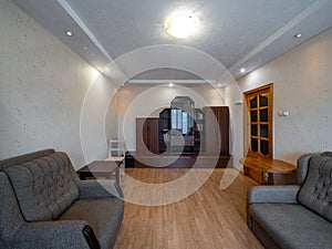 Modern interior of living room in apartment. Wooden furniture. Grey sofas.