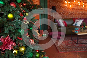 Modern interior of living room. Creative Christmas tree, contemporary fireplace and large olive sofa in loft interior