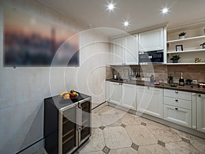 Modern interior of private house. Light spacious kitchen. Fresh fruits in plate.