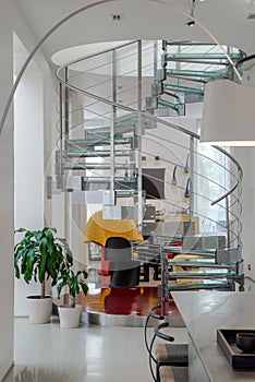 Modern interiro of luxury private house. Glass metal spiral staircase.