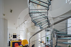 Modern interiro of luxury private house. Glass metal spiral staircase.