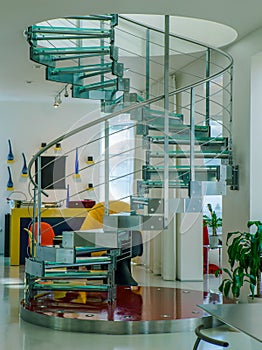 Modern interiro of luxury private house. Glass metal spiral staircase.