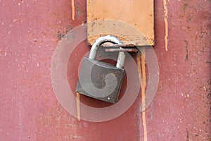A modern iron padlock hangs on steel the door. Locked door to the premise. Concept of protection, incarceration photo