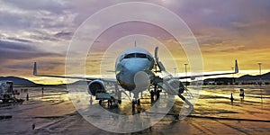 Modern Jet passenger transport airplane parked at the airport terminal. Commercial aircraft plane with beautiful warm sunset sky