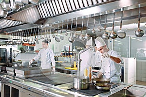 Modern kitchen. The chefs prepare meals in the restaurant`s kitchen photo